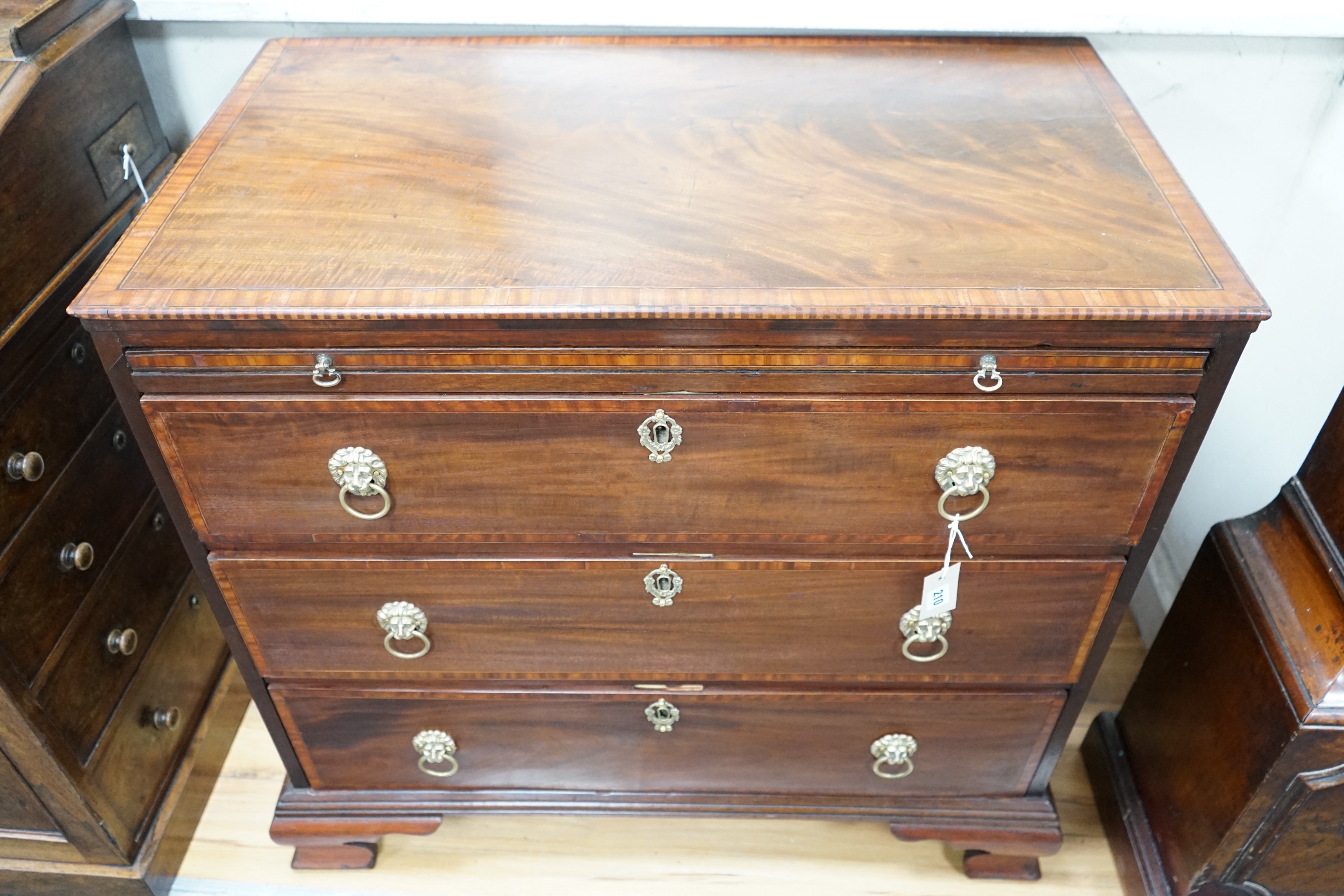 A George III and later banded mahogany chest of three drawers with brushing slide, width 85cm, depth 49cm, height 81cm *Please note the sale commences at 9am.